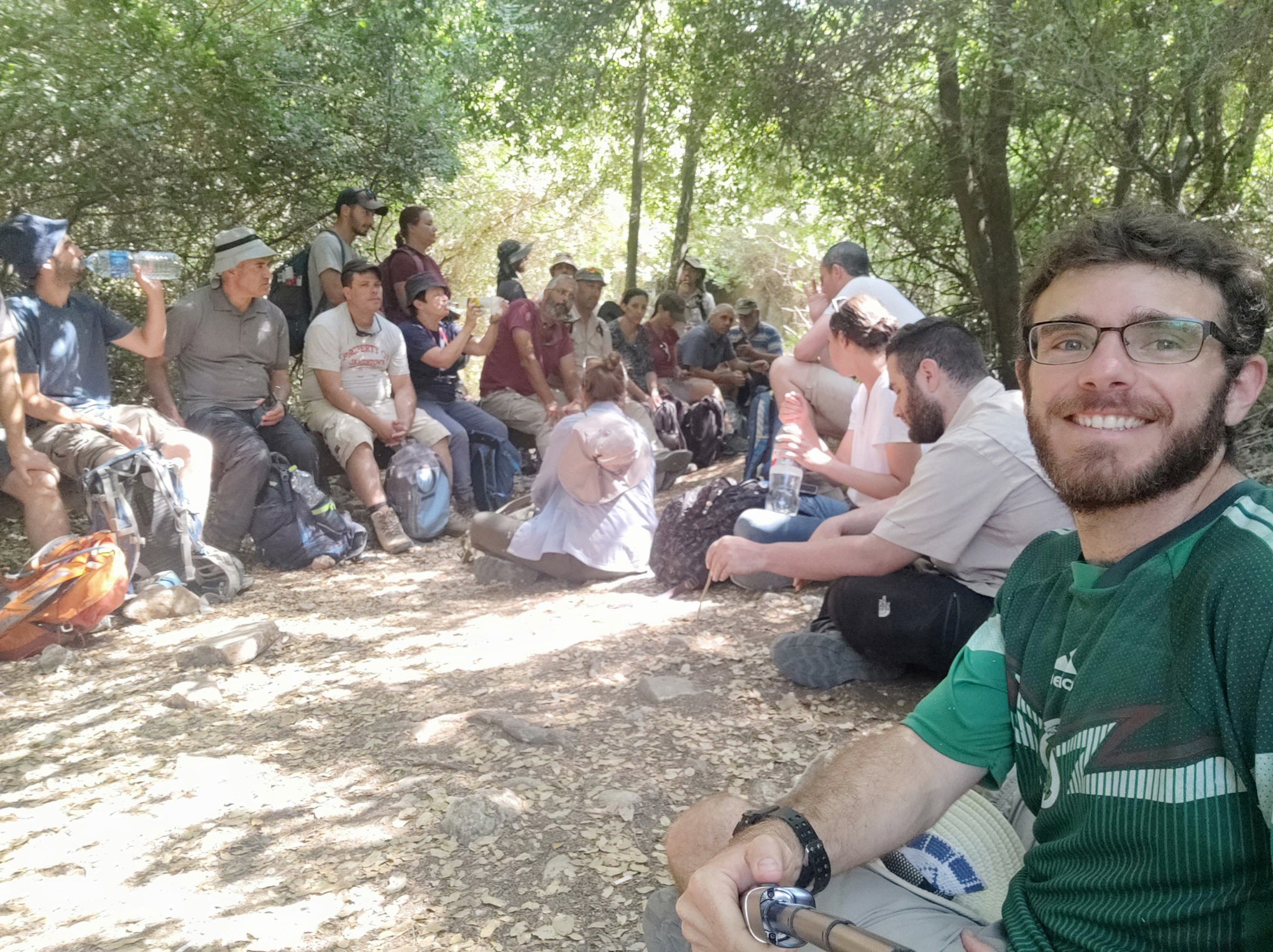 קבוצה יושבת יחד מתחת לעצים